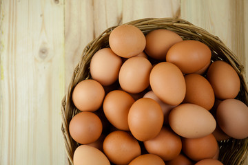 Full of Eggs put in a wicker basket in wooden background