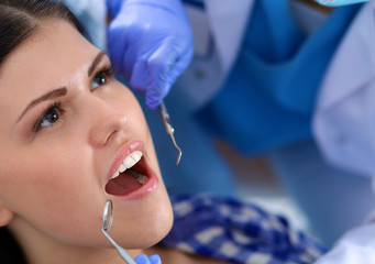 Woman dentist working at her patients teeth