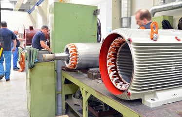 Maschinenbau von Elektromotoren - Fertigungshalle mit Arbeitern // industry: engineering of...