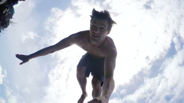 Extremely High Cliff Jump POV Young Man Backflips into Tropical Blue Ocean. Slow Motion.