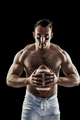 Shirtless American football player with ball