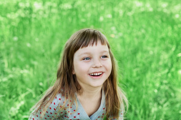 cute little girl laughing on the green meadow outdoor, happy childhood concept, child having fun, vintage toned