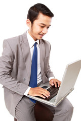 Portrait of smiling young businessman with laptop isolated on white background