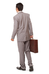 back view of a business man standing and holding a briefcase, isolated on white background