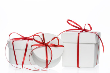 Drei weisse Geschenkboxen mit roter Schlaufe 