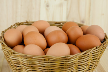 Full of Eggs put in a wicker basket in wooden background