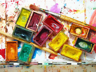 Watercolor painting and artistic tools on table