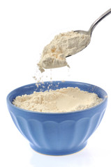 Cuillère de farine versée dans un bol