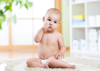 Cute little boy sitting with fingers in his mouth