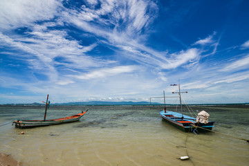 Fototapeta na wymiar Clear blue sky with cloud and 2 fishing boats in the sea in a shiny day.
