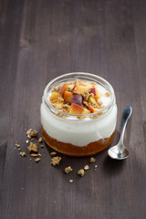 dessert with cream, granola and peach jam, vertical