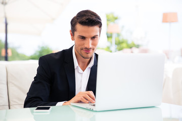 Businessman using laptop in restaurant