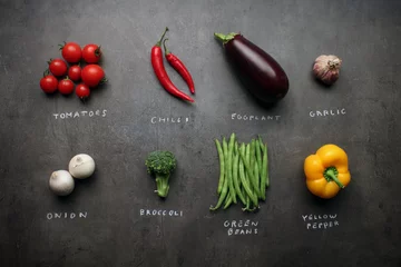 Fotobehang Groenten Verse groenten met krijtachtige tekens op grijze keukentafel