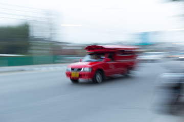 Fototapeta na wymiar red car driving on road, chiang mai, thailand, abstract blurred