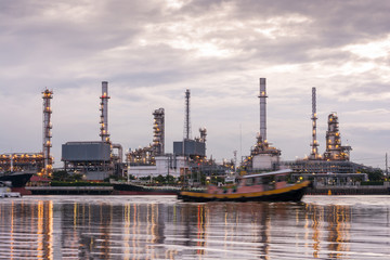 Obraz na płótnie Canvas Oil refinery, Tug boats are sailing through oil refinery industr