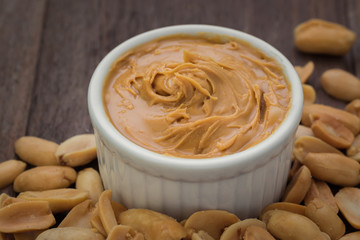 Peanut butter in bowl and peanuts