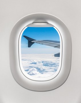 Looking out the window of a plane to the aircraft wing and cloud