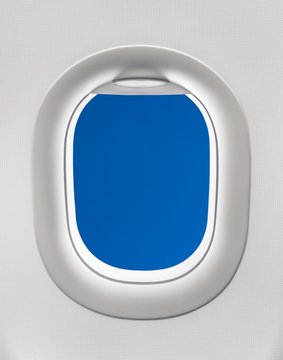 Looking out the window of a plane to the blue sky