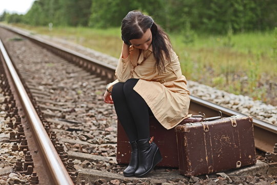 woman with a suitcase on the rails