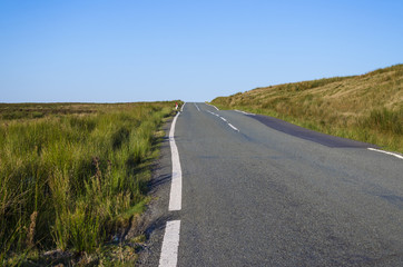A country lane ascends across moorland. A typical scene found in many rural parts of England, Wales or Scotland.