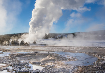 Fototapeta na wymiar old faithful eruption with other hot springs landscape