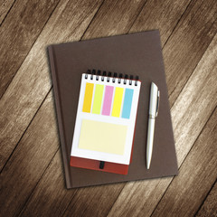 notebook and pen on wooden background