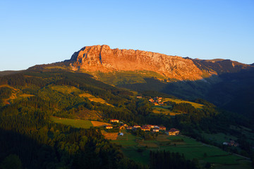 Obraz premium Itxina mountain with Zaloa and Urigoiti villages at sunset
