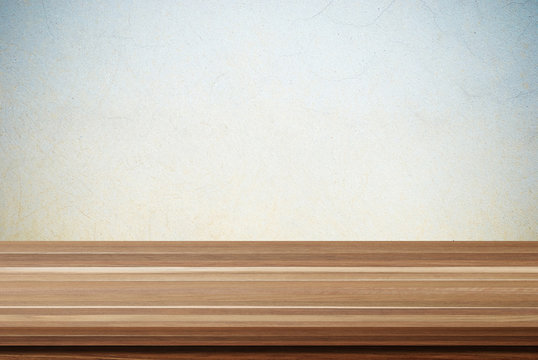 Empty wooden table over grunge cement wall background