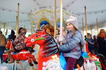 Adorable little girl enjoying a carousel ride