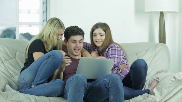 Girls hugging a guy on the couch