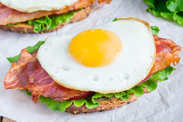 Open face sandwich with egg, bacon, tomato and lettuce
