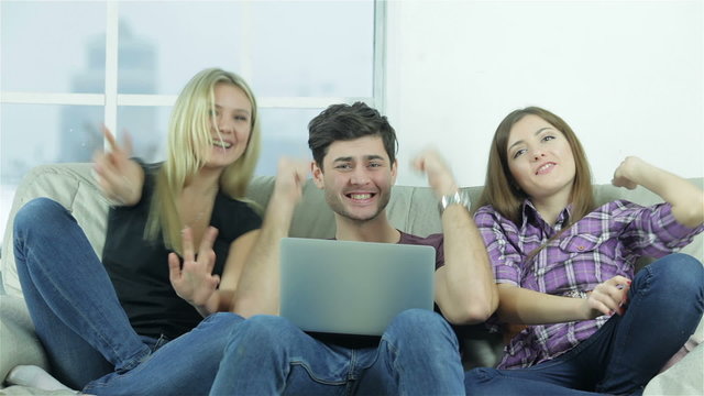 Guy and two girls show thumbs top directly into the camera