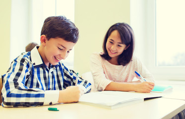 group of school kids writing test in classroom