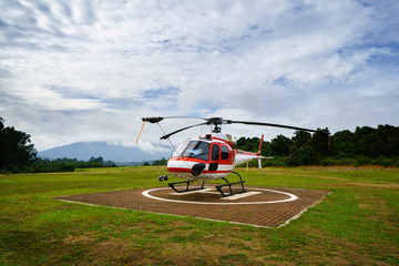 Helicopter parked at the helipad near forest