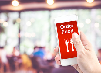 Hand holding mobile with Order food with blur restaurant backgro