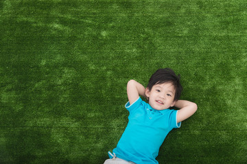 Cute asian child lying with colorful pilows