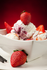 Strawberry icecream in a white bowl  with strawberries