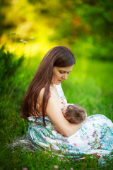 Mom feeds the baby, breastfeeding,summer