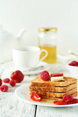 Fresh toast with raspberry and strawberry on white wooden backgr