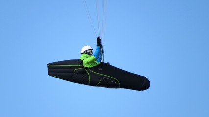 A hang glider in a clear blue sky.