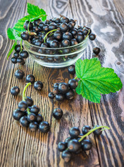 Black currants in bowl on wooden table
