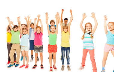 Fototapeta premium Kids stand together boys and girls rise hands 