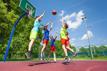 Tuinposter Children jump for flying ball during basketball © Sergey Novikov