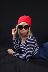 Woman laying down with red hat and sunglasses