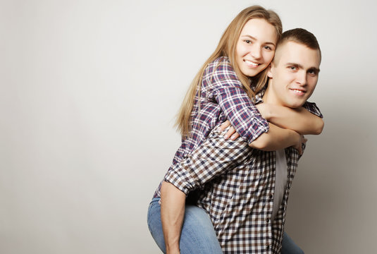 young man carrying girlfriend on his back.