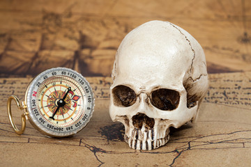 Human Skull and compass on Old map Background
