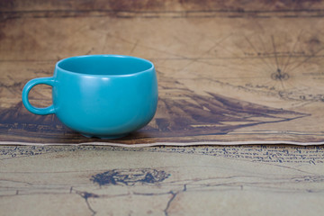 cup of coffee lies on an ancient map