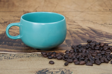 cup of coffee and bean lies on an ancient map