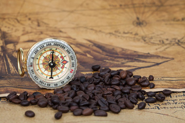 Vintage compass and bean lies on an ancient map