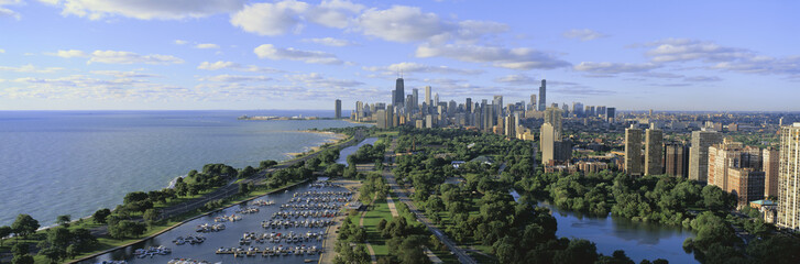 Fototapeta na wymiar This shows Lincoln Park, Diversey Harbor with its moored boats, Lake Michigan to the left and the skyline in summer. There is morning light on the city.
